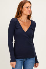 woman wearing a navy long sleeve wrap top paired with blue jeans