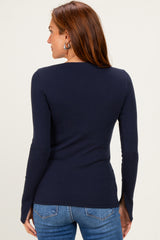 woman wearing a navy blue long sleeve ribbed top and blue jeans, showing the back view of the shirt