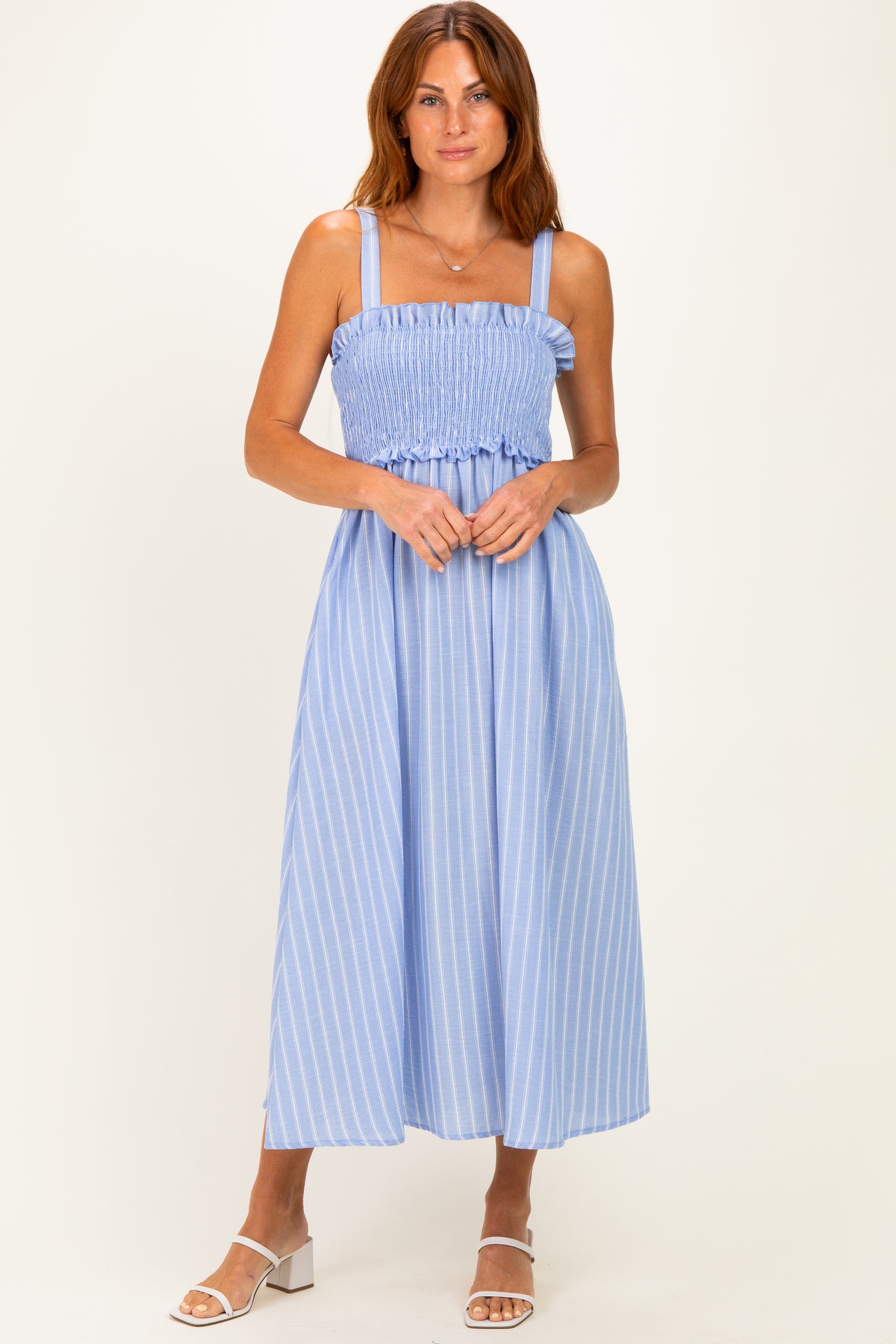 woman wearing a light blue striped maxi dress with a smocked bodice and adjustable straps