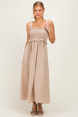 woman wearing a beige striped maxi dress with a smocked bodice and ruffle detail, smiling at the camera