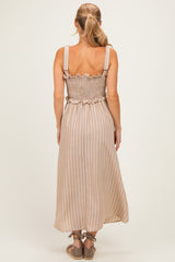 woman wearing a beige striped maxi dress with a smocked bodice and ruffle details, shown from the back