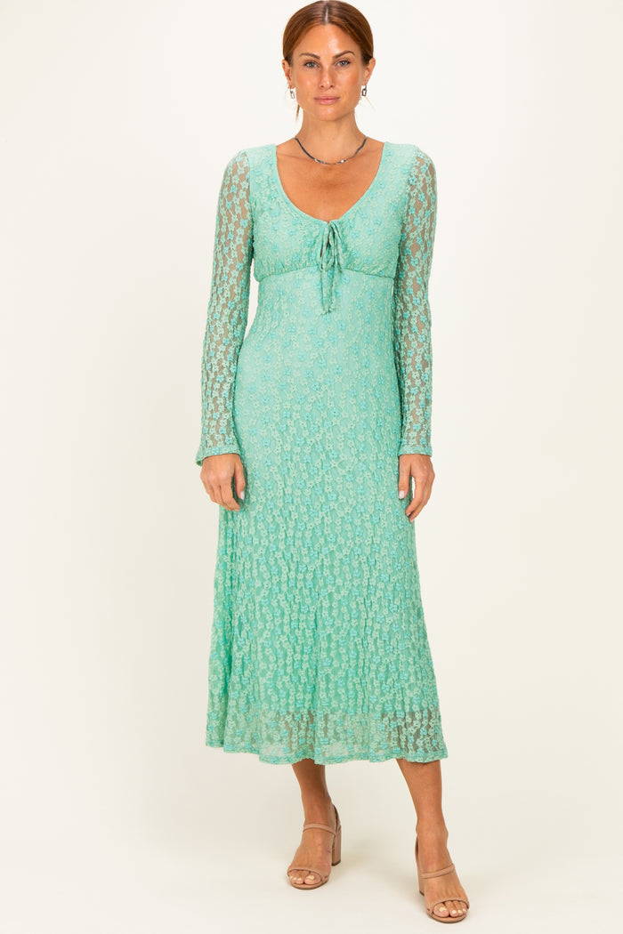 woman wearing a light green long sleeve maxi dress with a tie front and textured lace detail