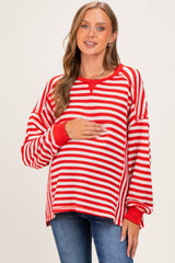 woman wearing a red and white striped maternity sweater and holding her baby bump
