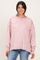 woman wearing a pink and white striped oversized sweatshirt with a relaxed fit and long sleeves
