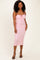 woman wearing a pink ruched midi dress with adjustable straps and a tie detail at the bust