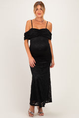 woman wearing a black lace off-the-shoulder maternity gown with a fitted silhouette and a visible baby bump