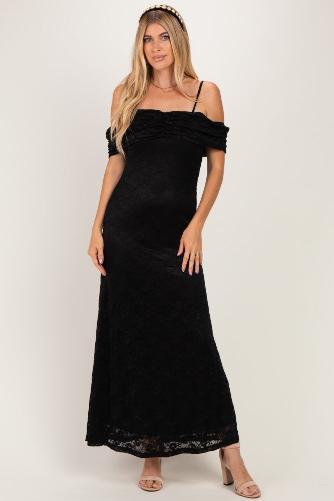 woman wearing a black off-the-shoulder lace maxi dress with a fitted silhouette and strappy details
