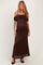 woman wearing a brown lace maternity maxi dress with off-the-shoulder straps and a fitted silhouette, showing her baby bump