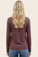 woman wearing a maroon and white striped long sleeve top with a round neckline and styled wavy hair