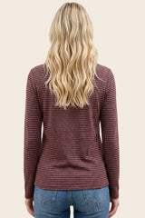 woman wearing a maroon and white striped long sleeve top with a round neckline and styled wavy hair
