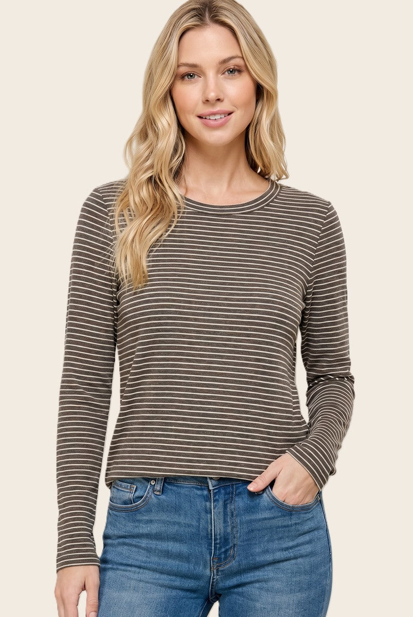 woman wearing a brown striped long sleeve top with a round neckline and relaxed fit, paired with blue jeans