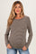 woman wearing a brown and cream striped maternity top with long sleeves and a relaxed fit, showing her baby bump