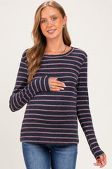 woman wearing a navy striped maternity top and holding her baby bump