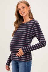 woman wearing a navy blue and red striped maternity top highlighting her baby bump