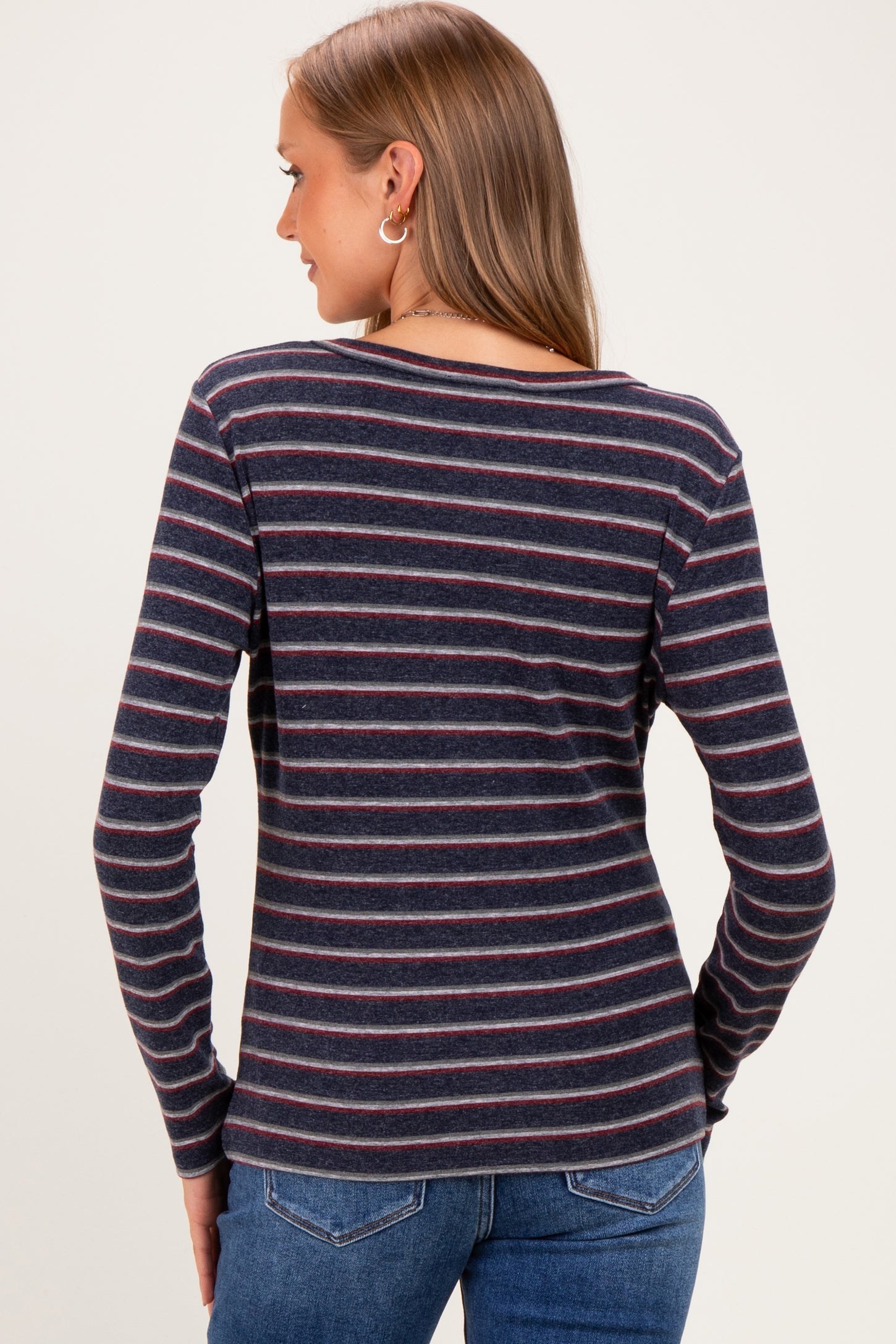 woman wearing a navy striped long sleeve maternity top viewed from the back