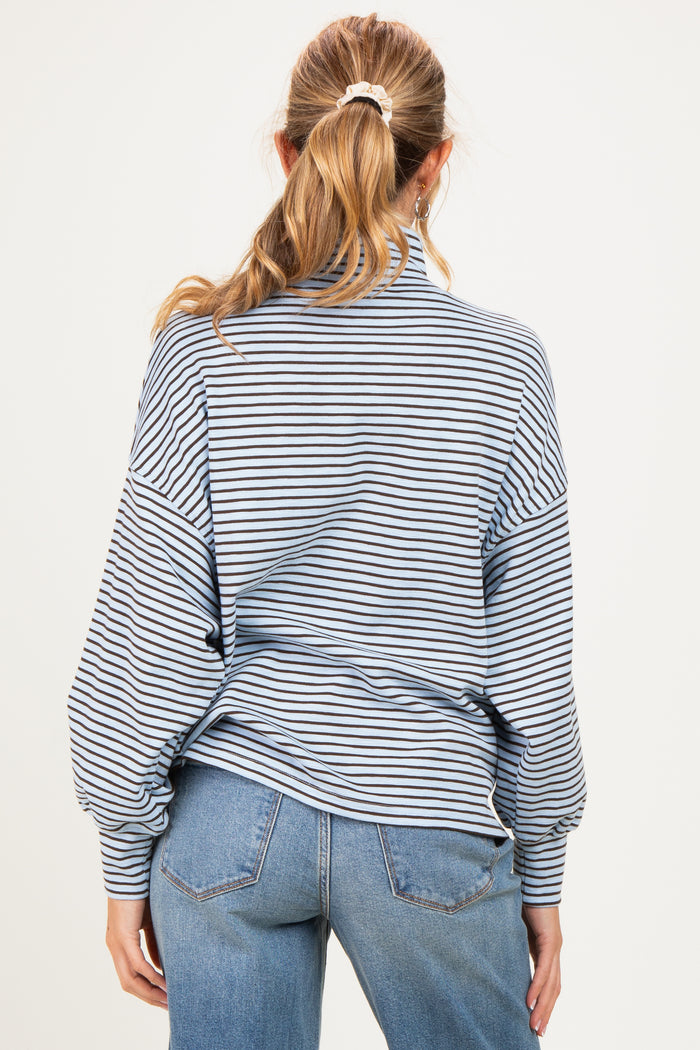 woman wearing a light blue striped maternity sweater with a relaxed fit and balloon sleeves, seen from the back