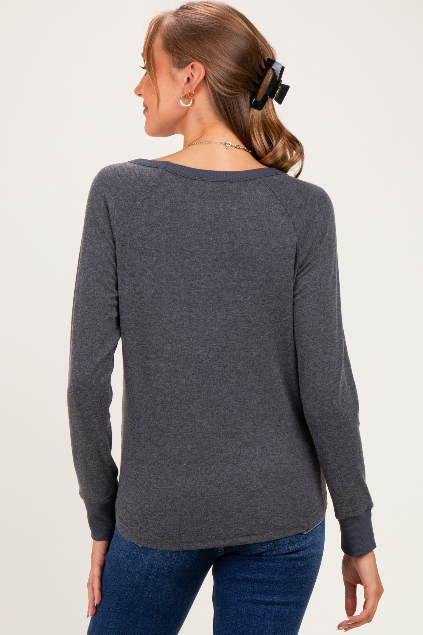 woman wearing a gray long sleeve maternity top with ribbed cuffs and back view visible