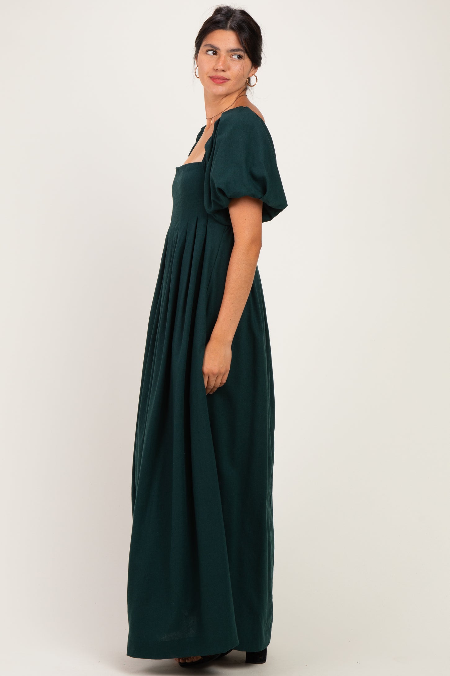woman wearing a dark green maxi dress with puffed short sleeves and a square neckline