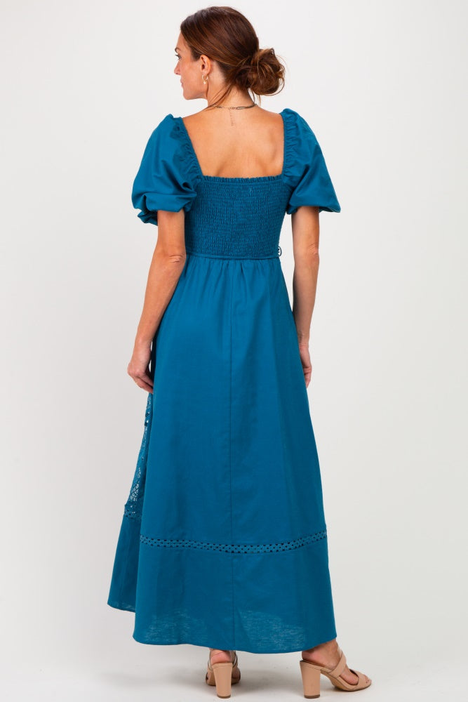 woman wearing a teal maxi dress with puff sleeves and a smocked bodice, seen from the back