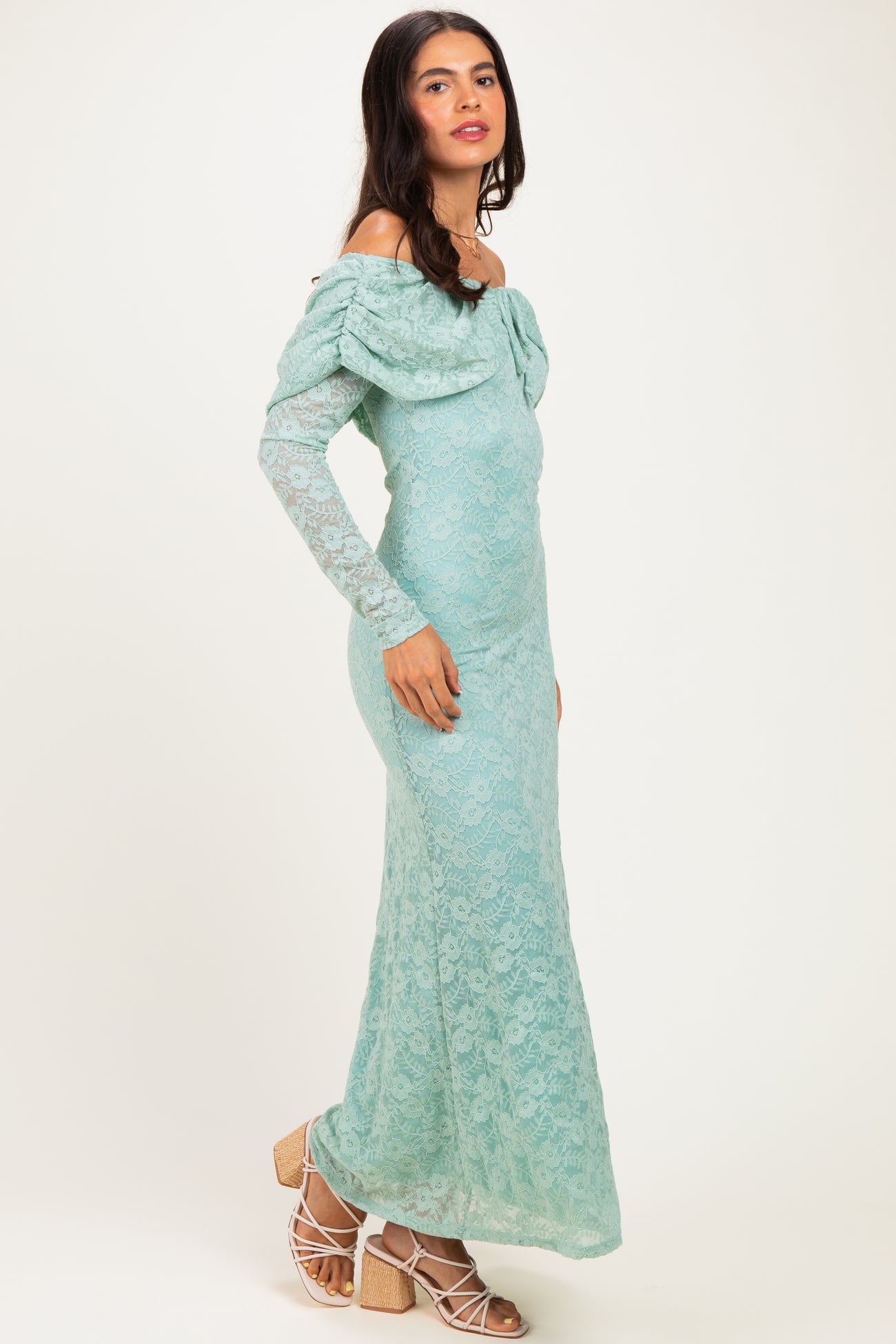 woman wearing a mint green off-shoulder lace maxi dress with long sleeves and ruffled detailing