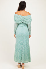 woman wearing a mint green off-shoulder lace gown with a draped back and long sleeves