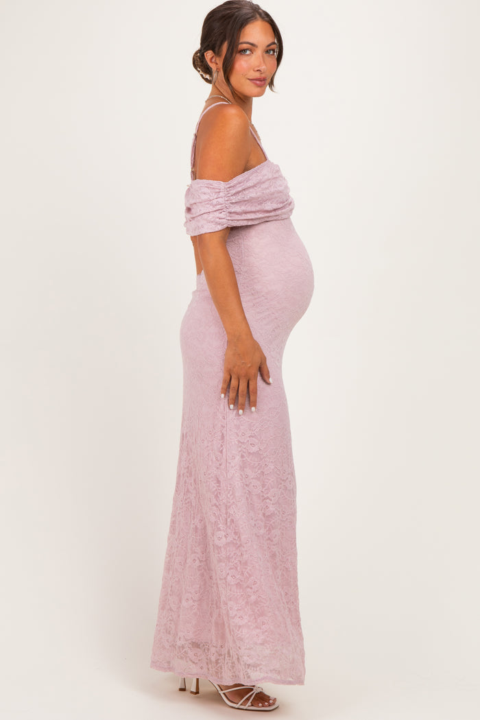 woman wearing a light pink off-shoulder lace maternity gown with a visible baby bump