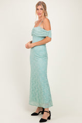 woman wearing a mint green lace off-the-shoulder maxi dress with a ruched bodice and spaghetti straps