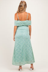 woman wearing a mint green lace off-the-shoulder maternity dress, showing a fitted bodice and flowing skirt from the back