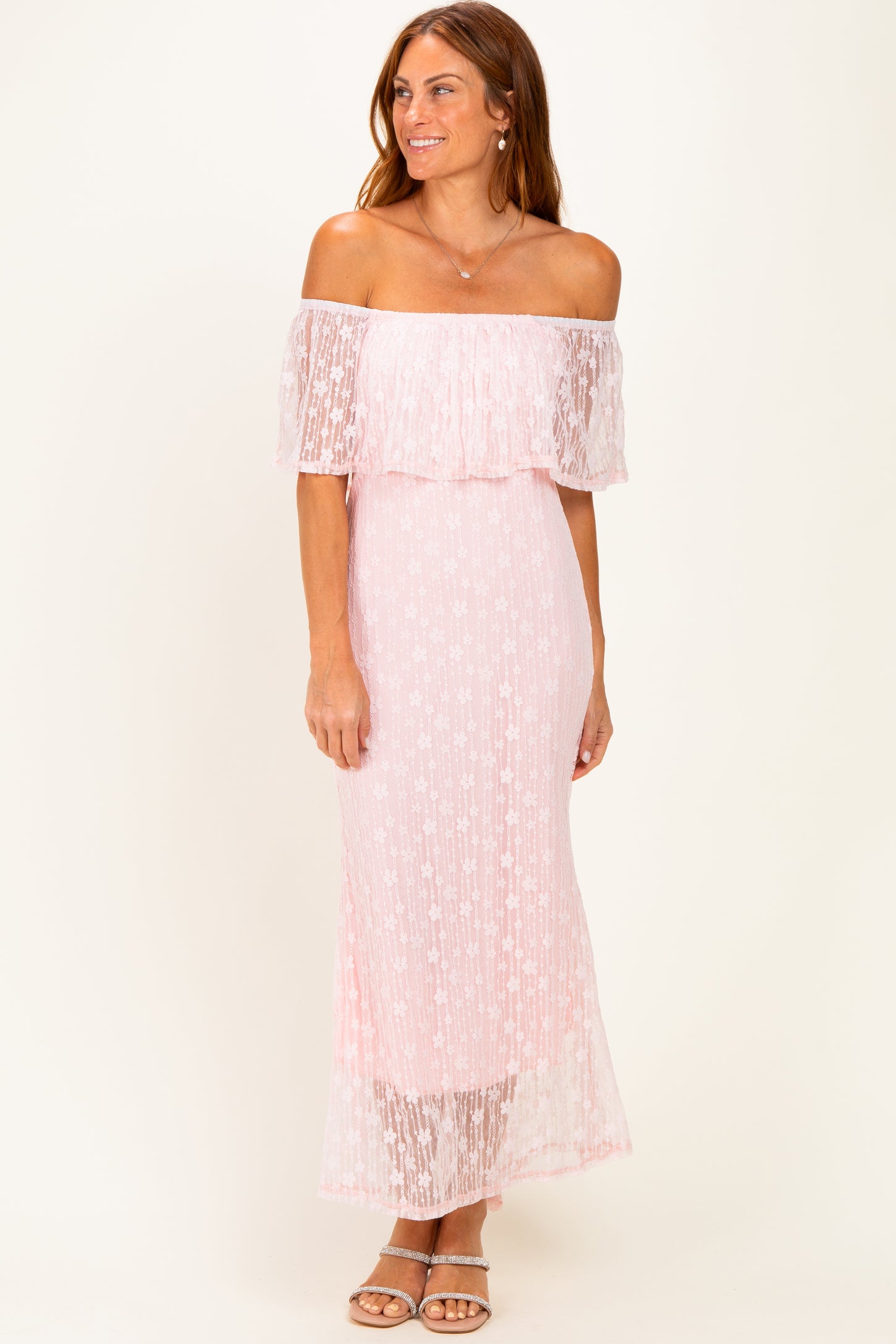 woman wearing a pink off-the-shoulder maxi dress with sheer overlay and floral details