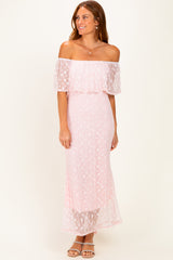 woman wearing a pink off-the-shoulder maxi dress with sheer overlay and floral details