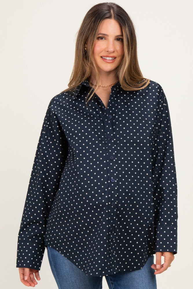 woman wearing a navy maternity button-up shirt with white polka dots and a visible baby bump