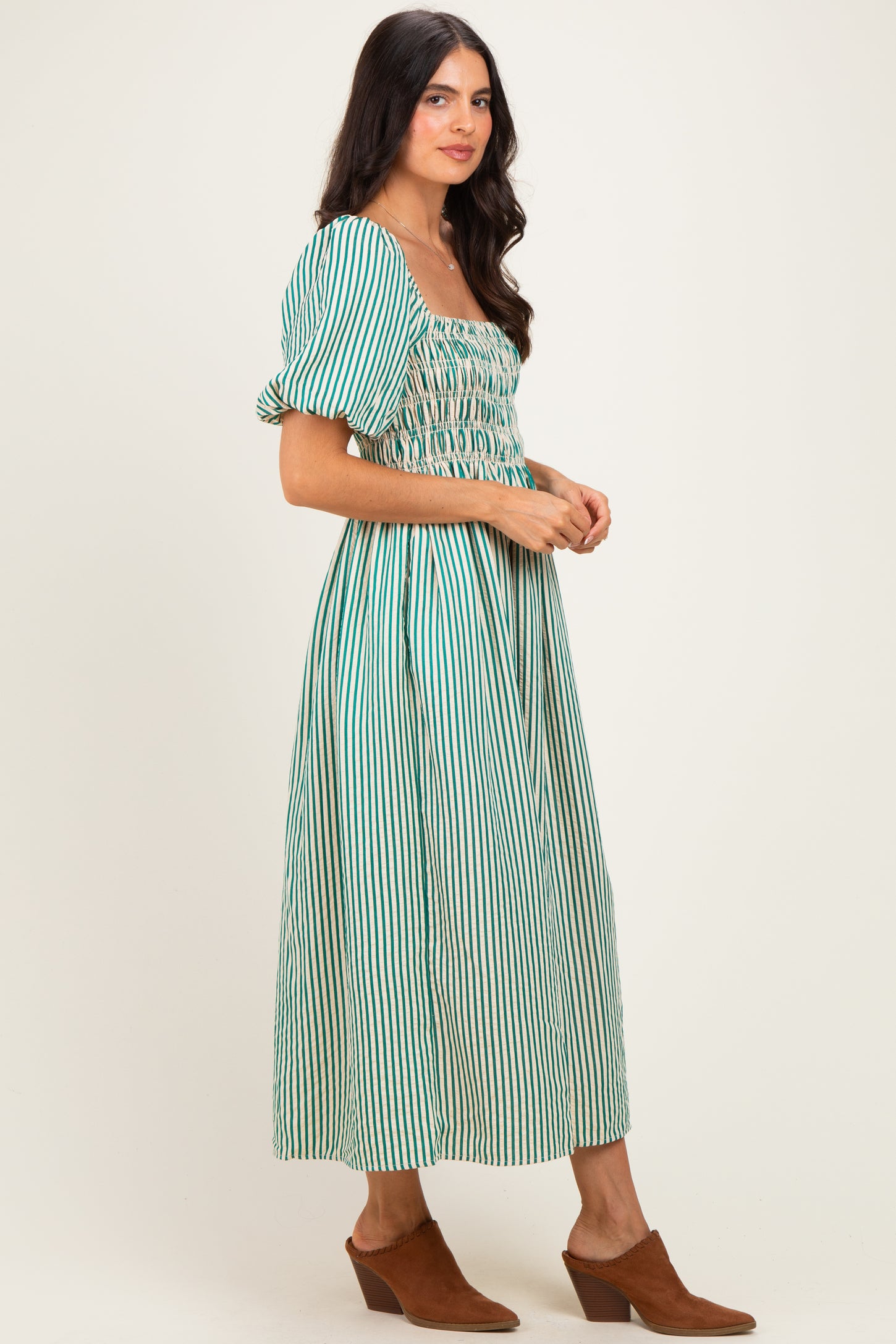 woman wearing a green and white striped maxi dress with puff sleeves and a smocked bodice