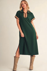 woman wearing a green midi dress with short sleeves, a collar, and side slits, paired with tan cowboy boots