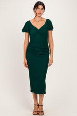 woman wearing a dark green midi dress with puff sleeves and a ruched design