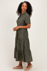 woman wearing a dark green floral print midi dress with short sleeves and a tiered skirt