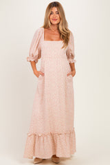 woman wearing a pink floral maternity maxi dress with puff sleeves and side pockets