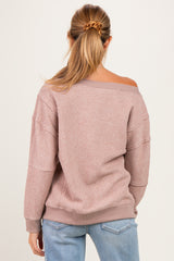 woman wearing a light pink off-shoulder maternity sweater with ribbed texture and long sleeves