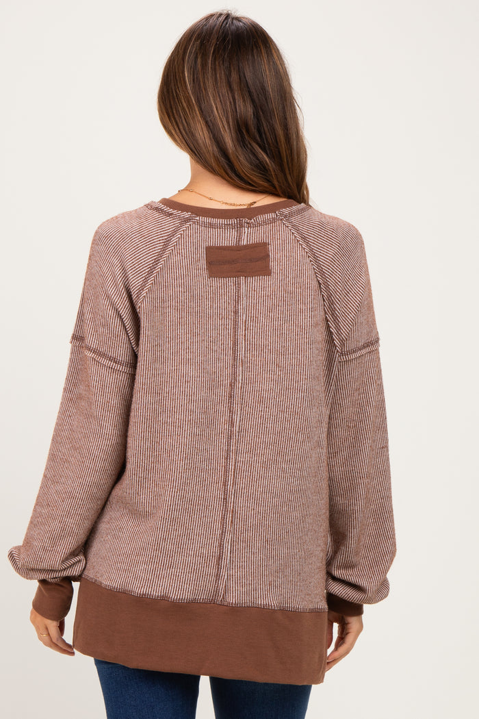 woman wearing a brown striped maternity sweatshirt with a relaxed fit and contrasting color hem