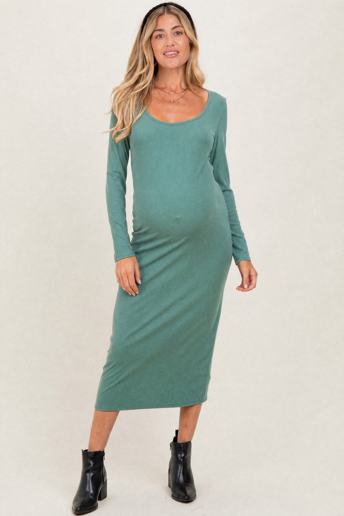 woman wearing a green long sleeve ribbed maternity dress and showing her baby bump