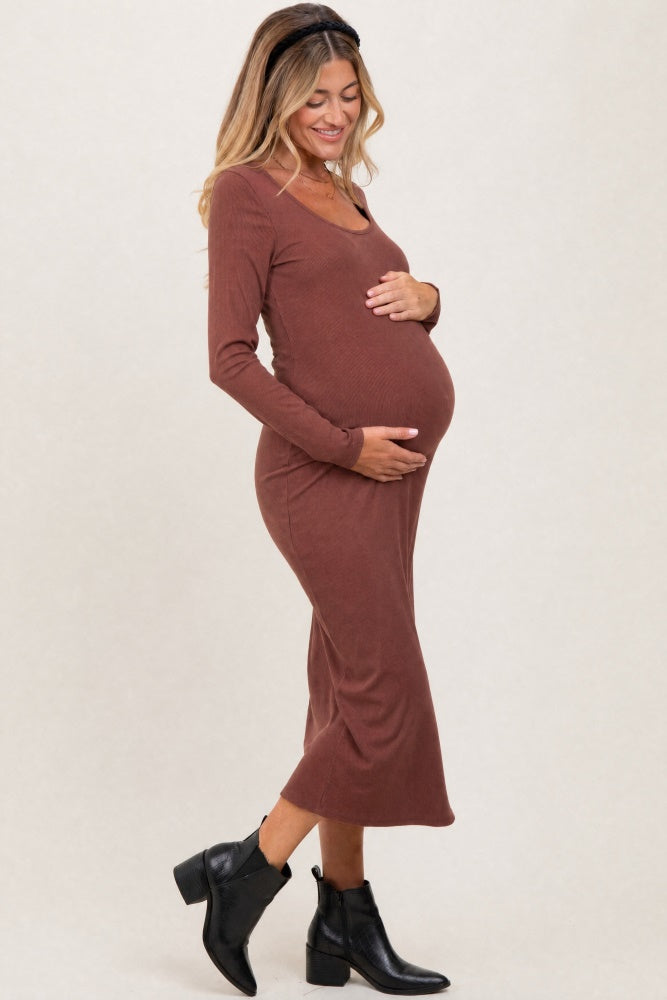 woman wearing a brown long sleeve maternity dress and holding her baby bump