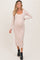 woman wearing a beige long sleeve maternity dress with a scoop neckline and a visible baby bump