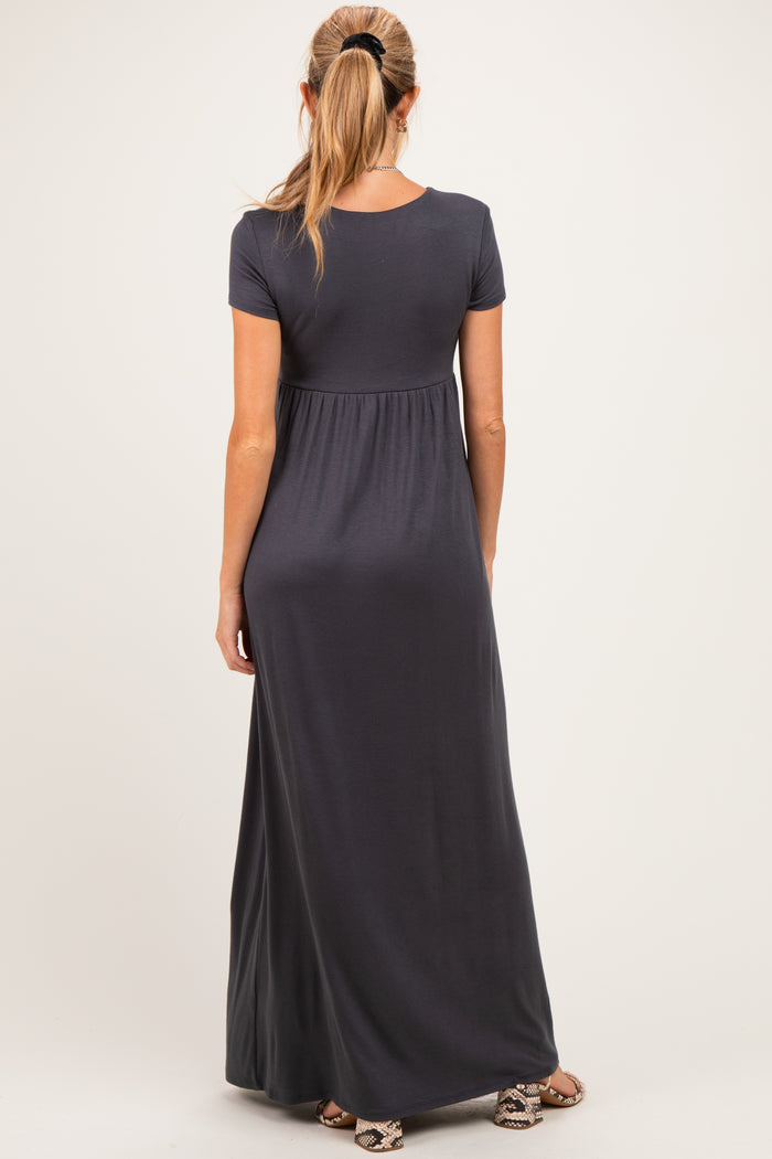 woman wearing a dark gray short sleeve maternity maxi dress, showing the back view