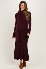 woman wearing a burgundy knit maternity dress with long sleeves and a scarf, showing her baby bump