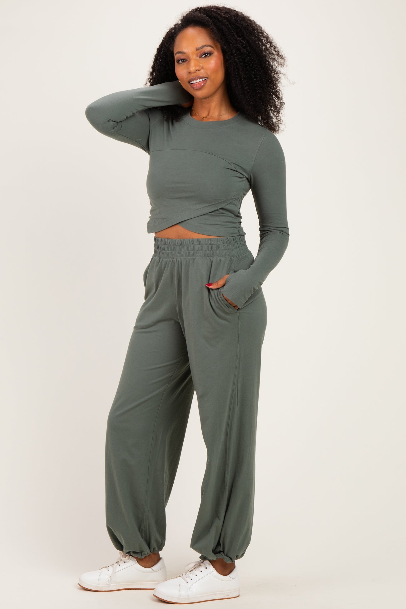 woman wearing a grey long sleeve crop top and matching high-waisted pants with pockets