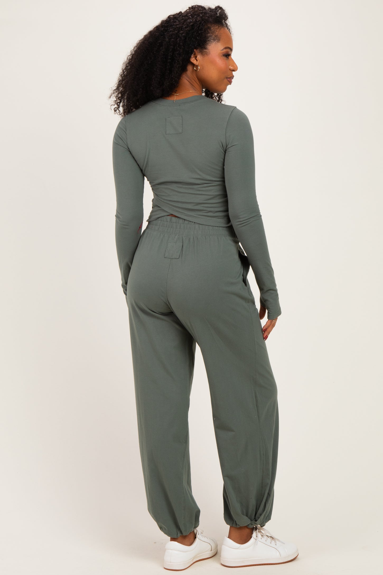 woman wearing a green long sleeve top and matching jogger pants, showing the back view with elastic waistband and relaxed fit