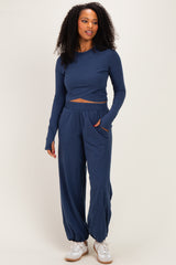 woman wearing a navy blue long sleeve cropped top and matching wide-leg pants with a relaxed fit