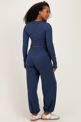 woman wearing a navy blue long sleeve top and matching loose-fitting pants, viewed from the back