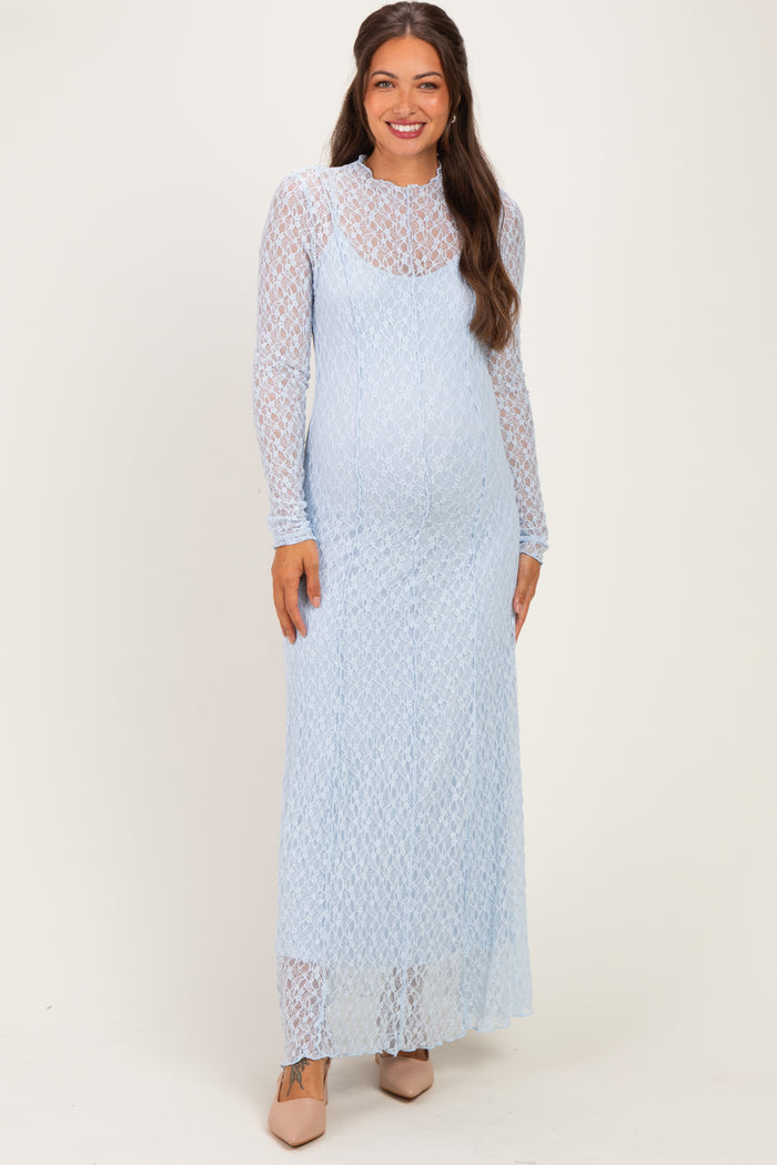 woman wearing a light blue lace maternity maxi dress with long sleeves and a visible baby bump