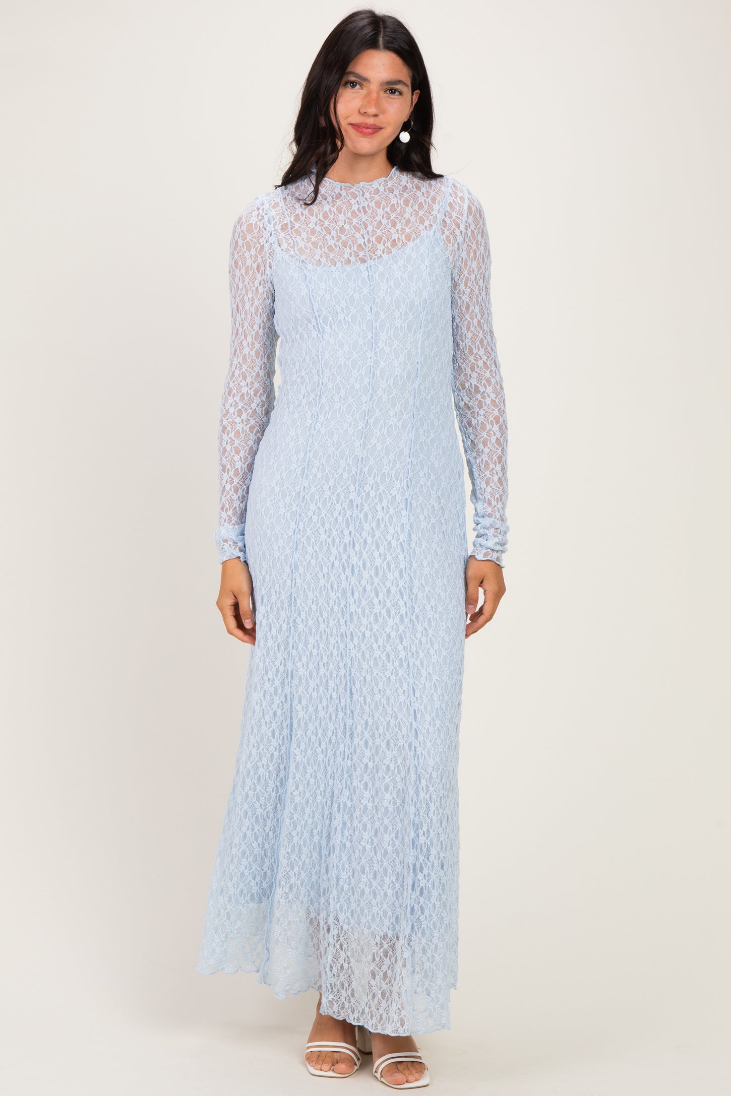 woman wearing a light blue long sleeve lace maxi dress with a fitted silhouette and high neckline