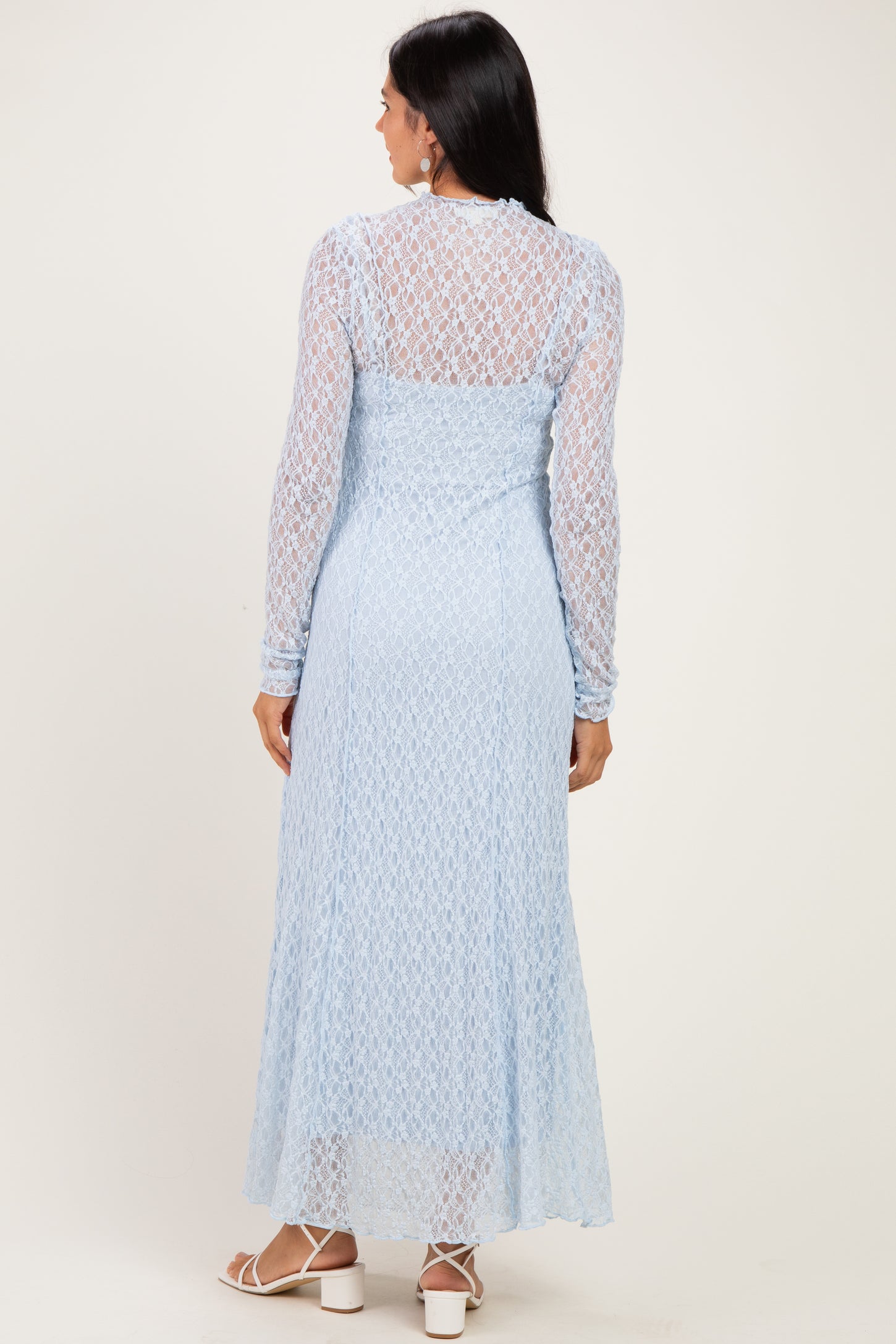 woman wearing a light blue long sleeve maxi dress with lace detailing, view from the back